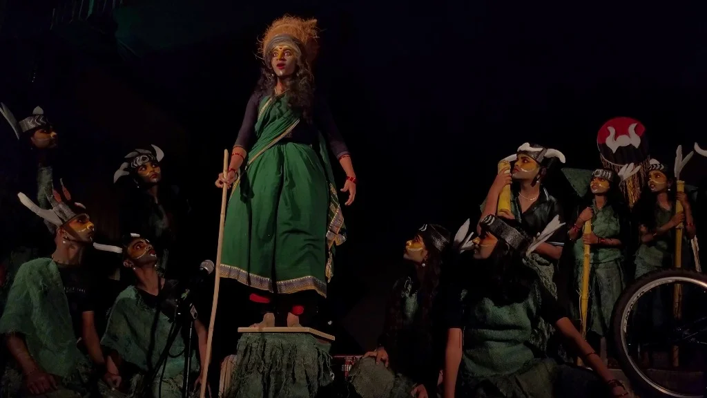 Forest Elder character standing on pedestal surrounded by student tribe in Mayadveepa